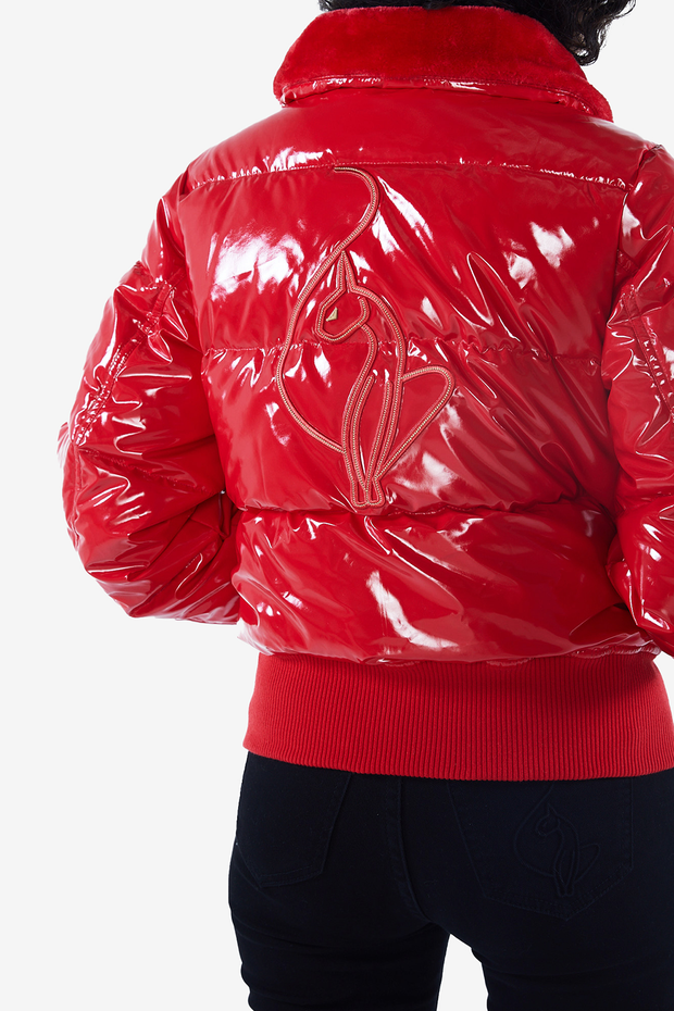 Baby Phat reissue OG puffer jacket in gloss red is a glossy red lacquer jacket that features a faux fur trim hood, cat logo detailing on the front and back, gold buttons, and a cat zipper pull.