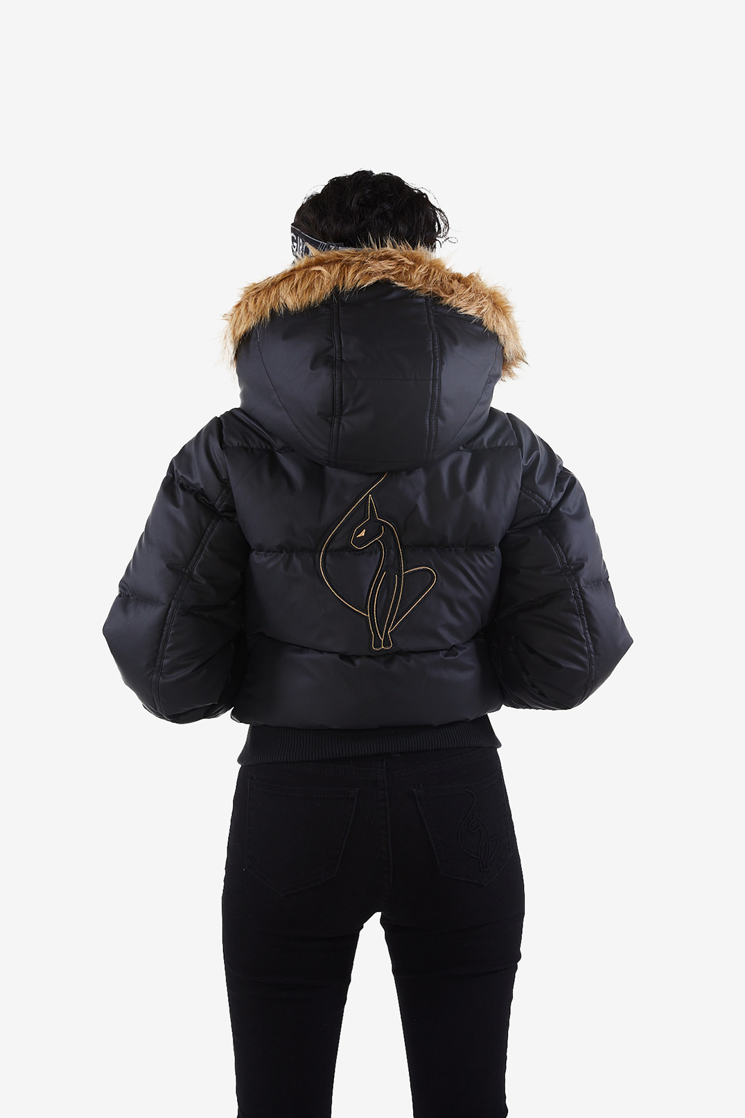 Baby Phat reissue OG puffer jacket in onyx is a matte black jacket that features a faux fur trim hood, cat logo detailing on the front and back, gold buttons, and a cat zipper pull.