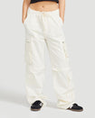 Front view image of standard sized model’s legs wearing off white cargo pant with tied waist and belt loops. Pants feature exaggerated pocket detailing down both legs and hidden zippers below the knees. 