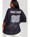 Back view image shows plus sized model wearing black oversized jersey with black rhinestones all over. Jersey features grey 99 logo large at center back with grey rhinestones. Jersey features large grey Baby Phat varsity logo across upper back.