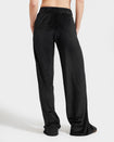 Standard sized model shown wearing black velour sweatpants. Pants feature a wide leg, open bottom fit with a rhinestone Baby Phat cat logo on the wearer's left upper thigh. Pants feature pockets and an elastic waistband with a drawstring tie.