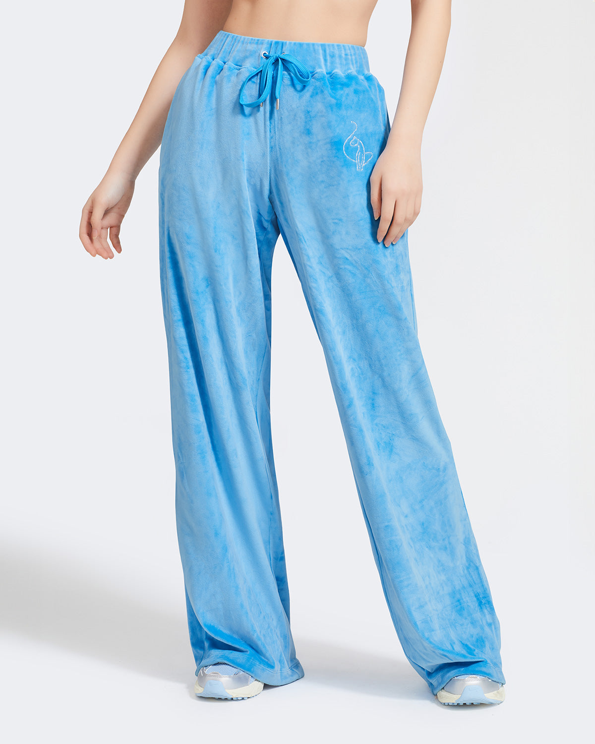 Standard sized model shown wearing blue velour sweatpants. Pants feature a wide leg, open bottom fit with a rhinestone Baby Phat cat logo on the wearer's left upper thigh. Pants feature pockets and an elastic waistband with a drawstring tie.