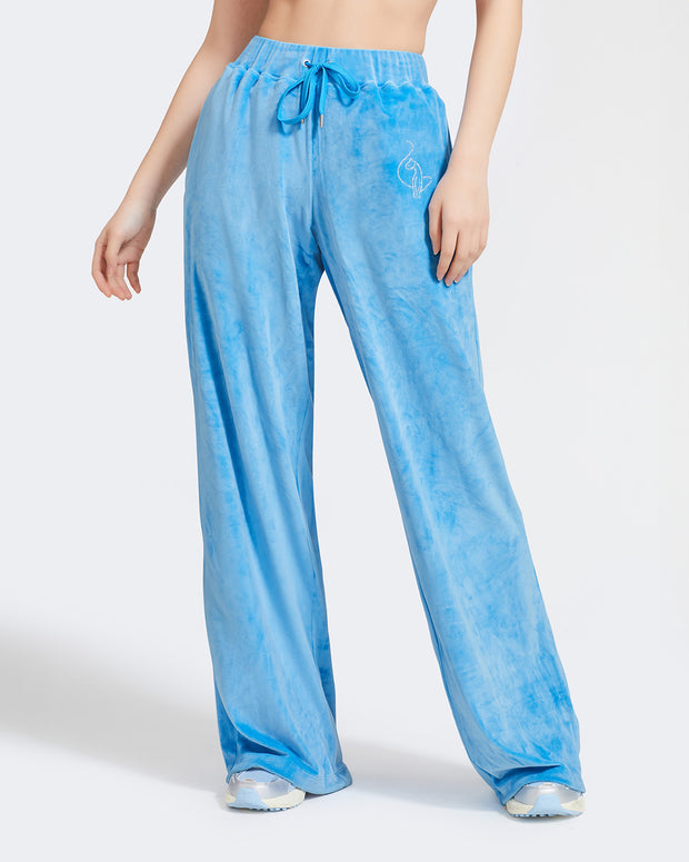 Standard sized model shown wearing blue velour sweatpants. Pants feature a wide leg, open bottom fit with a rhinestone Baby Phat cat logo on the wearer's left upper thigh. Pants feature pockets and an elastic waistband with a drawstring tie.