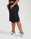 Side view image of standard sized model’s legs wearing black cargo short with visible belt loops. Shorts feature exaggerated pocket detailing down both legs and large pockets on both sides of rear.