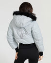 Model shown wearing light grey smoke puffer jacket. Coat features black faux fur detachable hood and Baby Phat script logo on front chest and oversized cat logo on the back. Jacket also features gold cat logo zipper pulls on the front pockets and center front.