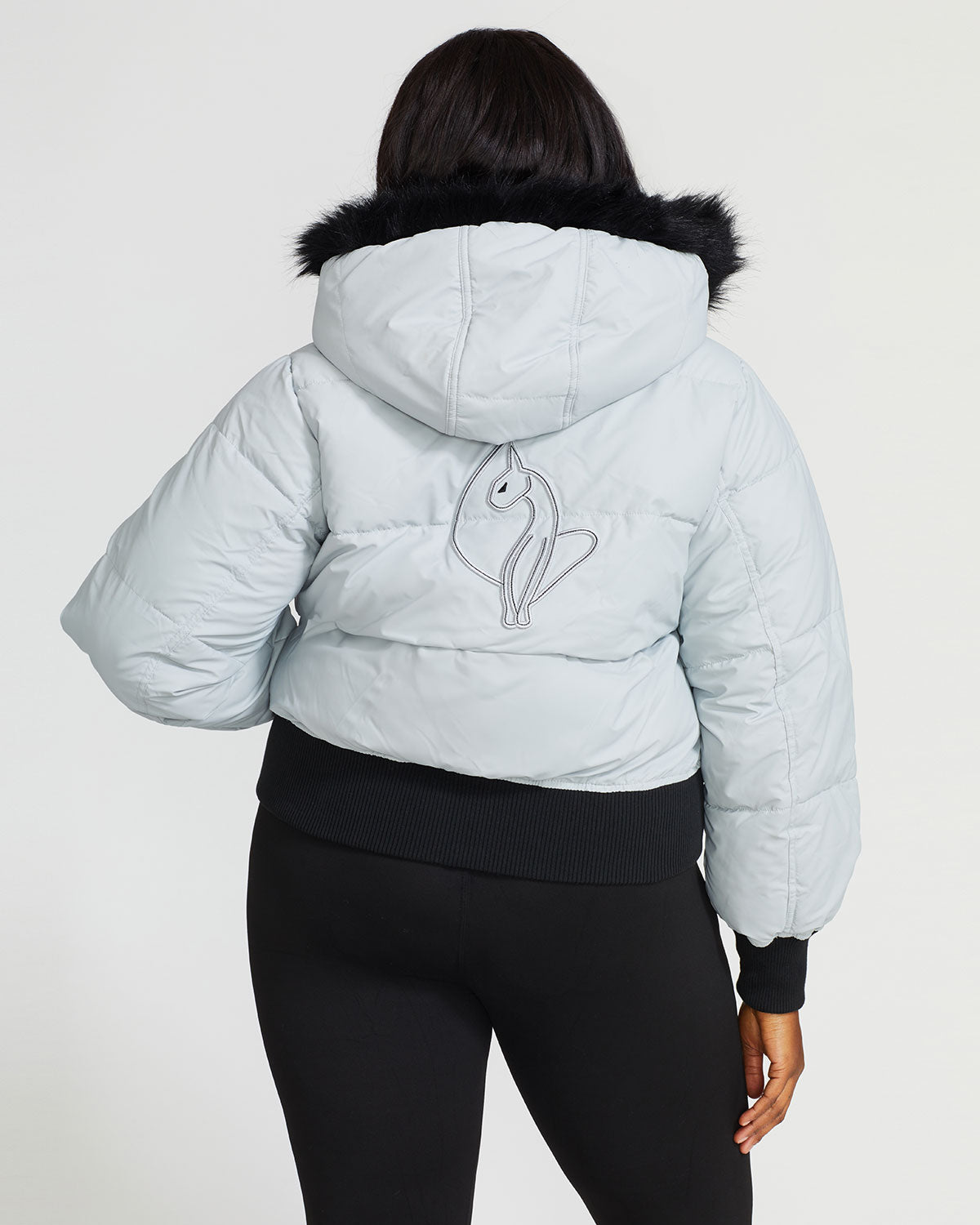 Plus sized model shown wearing light grey smoke puffer jacket. Coat features black faux fur detachable hood and Baby Phat script logo on front chest and oversized cat logo on the back. Jacket also features gold cat logo zipper pulls on the front pockets and center front.