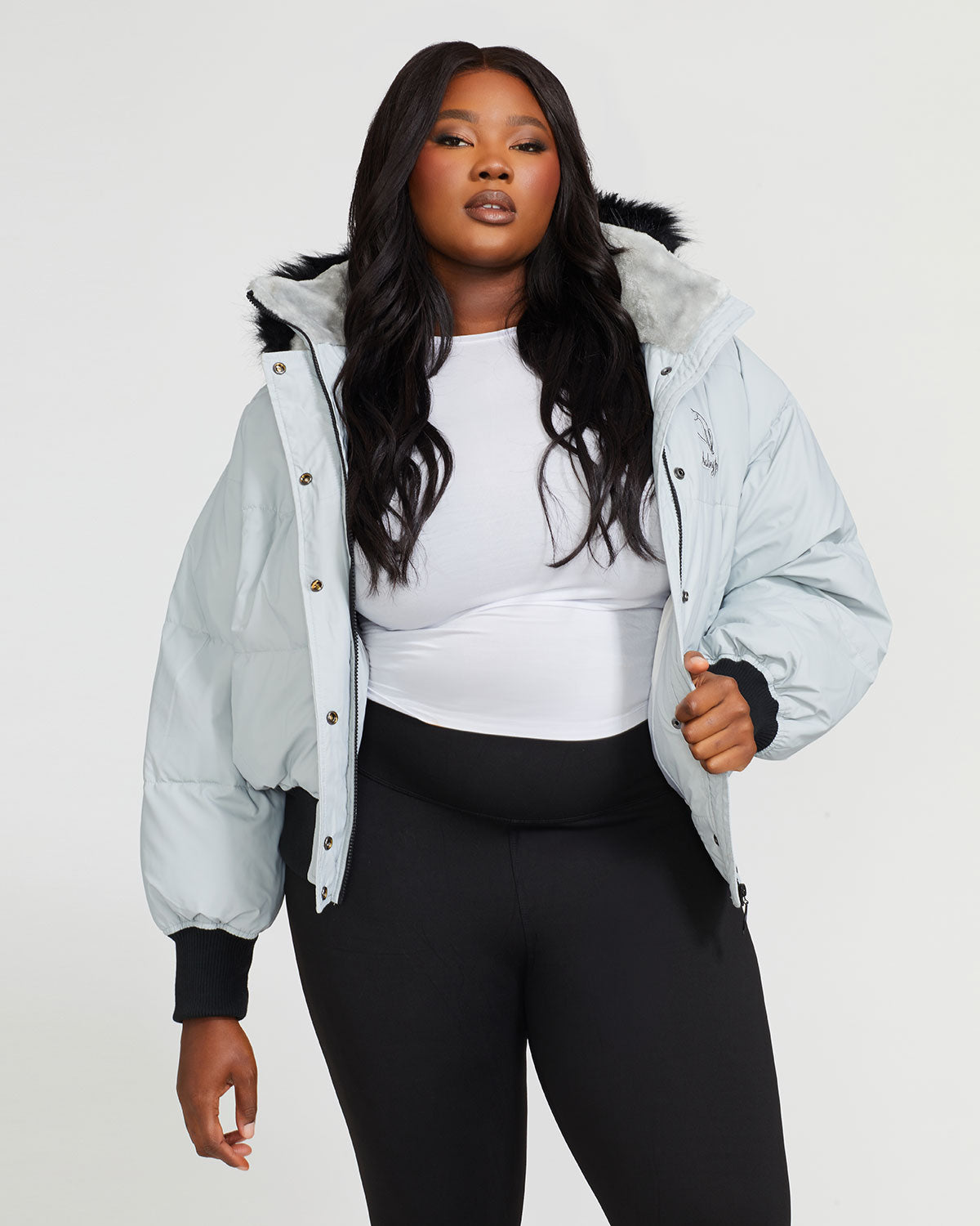 Plus sized model shown wearing light grey smoke puffer jacket. Coat features black faux fur detachable hood and Baby Phat script logo on front chest and oversized cat logo on the back. Jacket also features gold cat logo zipper pulls on the front pockets and center front.