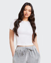 Standard sized model shown wearing white baby tee t-shirt with rhinestone Baby Phat cat logo on center front. 
