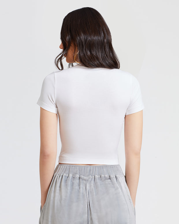 Back view image of standard sized model shown wearing white baby tee t-shirt with rhinestone Baby Phat cat logo on center front. 
