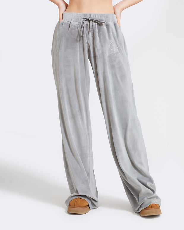 Standard sized model shown wearing grey velour sweatpants. Pants feature a wide leg, open bottom fit with a rhinestone Baby Phat cat logo on the wearer's left upper thigh. Pants feature pockets and an elastic waistband with a drawstring tie.