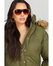 Model shown wearing olive green puffer jacket. Coat features faux fur detachable hood and Baby Phat script logo on front chest and oversized cat logo on the back. Jacket also features gold cat logo zipper pulls on the front pockets and center front.