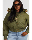 Plus sized model shown wearing olive green puffer jacket. Coat features faux fur detachable hood and Baby Phat script logo on front chest and oversized cat logo on the back. Jacket also features gold cat logo zipper pulls on the front pockets and center front.