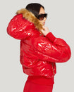 Model shown wearing glossy red puffer jacket. Coat features natural faux fur trimmed detachable hood and Baby Phat script logo on front chest and oversized cat logo on the back. Jacket also features gold cat logo zipper pulls on the front pockets and center front.