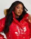 Plus sized model shown wearing glossy red puffer jacket. Coat features natural faux fur trimmed detachable hood and Baby Phat script logo on front chest and oversized cat logo on the back. Jacket also features gold cat logo zipper pulls on the front pockets and center front.