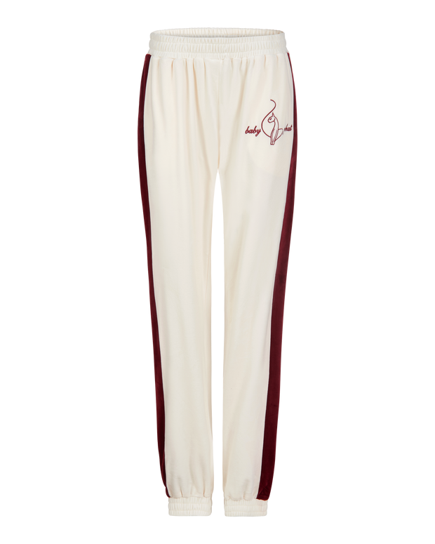 Baby Phat heritage sweatpant in cream features burgundy side stripe down the leg and cat and script brand logo on upper thigh. Pants feature elastic waistband and elastic hem.