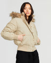 Model shown wearing light tan puffer jacket. Coat features natural faux fur trimmed detachable hood and Baby Phat script logo on front chest and oversized cat logo on the back. Jacket also features gold cat logo zipper pulls on the front pockets and center front.