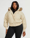 Plus sized model shown wearing light tan puffer jacket. Coat features natural faux fur trimmed detachable hood and Baby Phat script logo on front chest and oversized cat logo on the back. Jacket also features gold cat logo zipper pulls on the front pockets and center front.