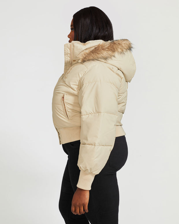 Plus sized model shown wearing light tan puffer jacket. Coat features natural faux fur trimmed detachable hood and Baby Phat script logo on front chest and oversized cat logo on the back. Jacket also features gold cat logo zipper pulls on the front pockets and center front.