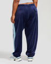 Back view image shows plus sized model wearing navy blue velour sweatpant with color blocked light blue stripe down both sides. Sweatpant features oversized flap pocket on rear right side.