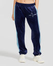 Standard sized model shown wearing navy blue velour sweatpant with color blocked light blue stripe down both sides. Sweatpant features embroidered Baby Phat script and cat logo on wearer's upper left thigh. Model has her hand in her pocket.