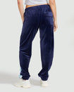 Back view image of standard sized model wearing navy blue velour sweatpant with color blocked light blue stripe down both sides. Sweatpant features oversized flap pocket on rear right side.