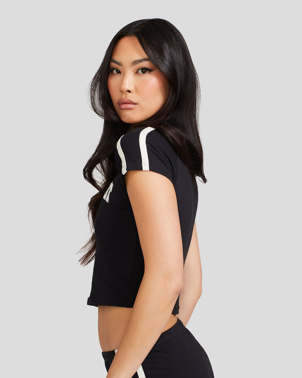 Standard sized model shown wearing black baby tee shirt with off white stripes on the shoulder.