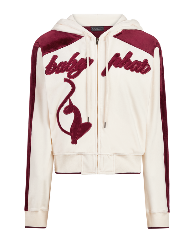 Velour zip up sweatshirt in cream features burgundy color blocking. Baby Phat script logo across the chest. Oversized cat logo on the front of jacket. Back of jacket features additional cat logo.