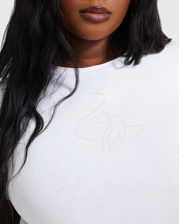 Plus sized model shown wearing white baby tee t-shirt with rhinestone Baby Phat cat logo on center front. 