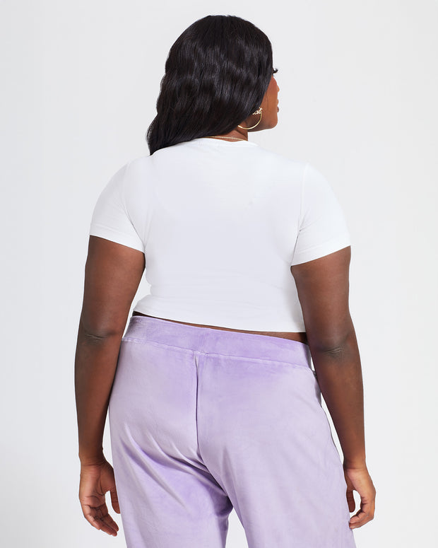 Plus sized model shown wearing white baby tee t-shirt with rhinestone Baby Phat cat logo on center front. 
